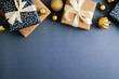 Christmas frame top border made of gift boxes and golden balls on dark blue background. Flat lay, top view, copy space. Merry Christmas and Happy New Year banner design.