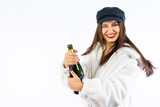 Fototapeta Panele - Young Latin girl celebrating New Years Eve on a white background. Opening a bottle of champagne very smiling