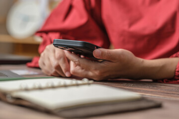 Poster - close up woman hand using credit card shopping online on mobile app on wood table at home