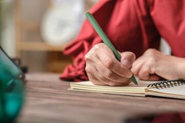 Poster - close up hand writing on notebook on wooden table