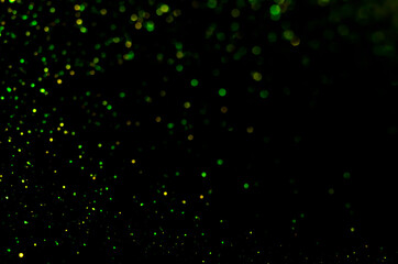 Yellow and green bokeh on a black background.