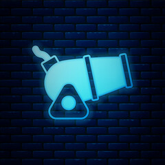 Poster - Glowing neon Cannon icon isolated on brick wall background. Medieval weapons. Vector