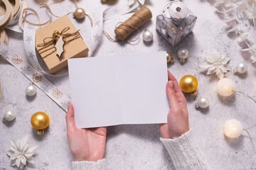 Female hands are holding a Christmas card. Festive atmosphere during Christmas time.