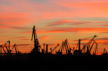 landscape with the silhouettes of cranes from the port of constanta in the evening