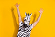 © deagreez - Photo of bizarre incognito guy in zebra mask arms up enjoy mardi-gras festival offer isolated over bright yellow color background