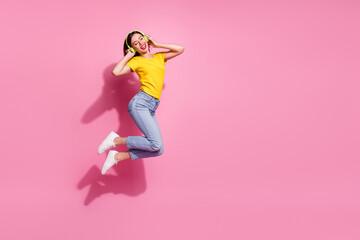 Wall Mural - photo of charming funny lady dressed yellow clothes enjoying songs arms earphones jumping high empty