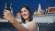 © tirachard - Happy young Asian girl tourist with casual style hold mobile phone take selfie photo peaceful picture of background temple in bangkok city at night, Lifestyle tourist travel holiday concept.