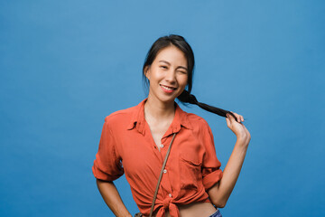 Wall Mural - Young Asia lady with positive expression, smile broadly, dressed in casual clothing and looking at camera over blue background. Happy adorable glad woman rejoices success. Facial expression concept.