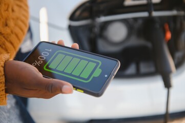 Wall Mural - African American man charging his electric car.