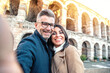 © Davide Angelini - Married couple of tourists taking a selfie portrait visiting Italy - Senior man and woman enjoying weekend vacation - Happy lifestyle concept