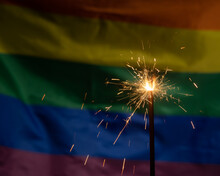 Sparklers With Waving Lgbt Rainbow Flag Background.