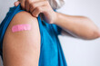 © Jo Panuwat D - man showing bandage after receiving covid 19 vaccine. Vaccination, herd immunity, side effect, booster dose, vaccine passport and Coronavirus pandemic