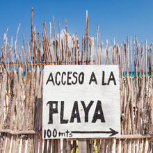 Beach Access Sign In Spanish, On A Fence By The Beach