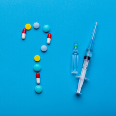 A question made from pills as a symbol of choice antibiotics against vaccine from Covid-19. Emergency help.