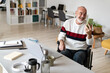 © Westend61 - Senior businessman on wheelchair smiling on video call through smart phone at home office
