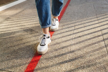 Woman Walking On Red Marking At Footpath