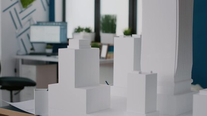 Poster - Close up of building model and maquette to design construction plan on table. Computer showing digital blueprints plans on computer monitor, used to create architectural presentation.