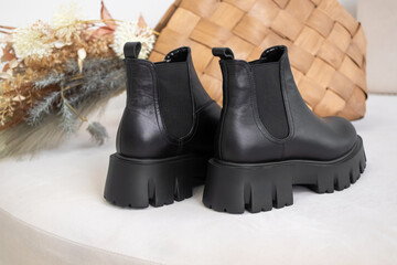 Wall Mural - Back side of black winter shoes. Women's leather boots with natural materials