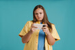 © Drobot Dean - Young white woman frowning while playing online game on cellphone
