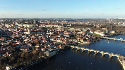 Wall Mural - 4k cinematic aerial video of the Prague castle, moldau river and charles bridge on a sunny winter day with blue sky