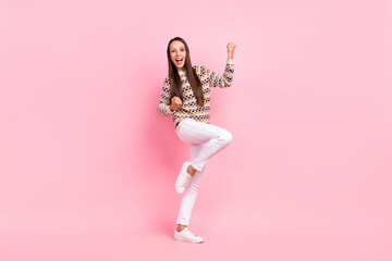 Sticker - Photo of lucky pretty young woman wear dotted sweater smiling walking rising fists isolated pink color background