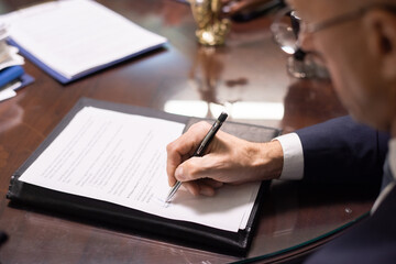 Aufkleber - Hand of contemporary lawyer or businessman signing contract or other juridical paper while sitting by table