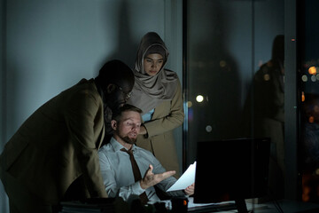 Poster - Confident economist showing financial document to colleagues and explaining them data that it contains