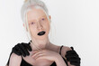 Male hands in black paint hugging albino woman isolated on white.
