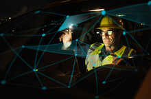 Engineer Wearing Hardhat Working On Illuminated Graph In Car