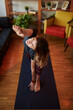 © chika_milan - A flexible yogi woman stretching and doing yoga at home. A woman in Extended Side Angle yoga pose.