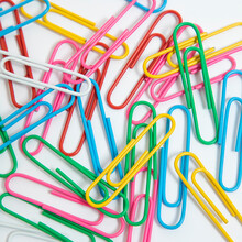 Colorful Paper Clips On A White Background. School, And Eduaction Idea.
