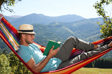 Sticker - Handsome man reading book in hammock outdoors on sunny day