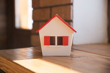 Wall Mural - house in winter - heating system concept and cold snowy weather with model of a house wearing a knitted cap