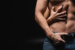 cropped view of woman scratching chest of muscular boyfriend on black.