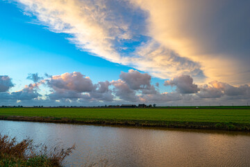 Wall Mural - wide angle view of beautiful sunset clouds over the dutch polder landscape near gouda, holland