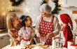 © JenkoAtaman - Happy multiracial kids help grandmother to cook Christmas cookies in kitchen during winter holidays