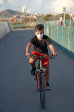 Kid Riding A Bicycle With Facemask