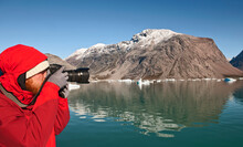 Man Taking Picture With A Digital SLR Camera In South Greenland