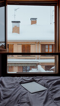 Blizzard Against Building Seen From The Bed With A Laptop. Snowy Day