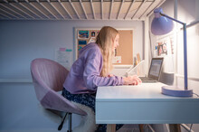 Tween Girl Sitting At Desk At Home Attending Remote School