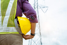 Electrical Engineer Holding Safety Helmet Working At Electric Po
