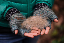 Woman Holds Onto A Dead Leaves Wearing Gloves In Winter