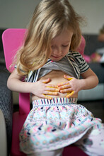 Cute Happy Little Girl Artist Printing Yellow Painted Palms On Her Belly.