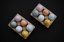 Overhead View Of Colorful Easter Eggs In Egg Carton On Black