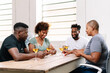 © PICHA - Friends playing cards while enjoying wine at home
