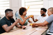 © PICHA - Friends playing cards while enjoying wine at home