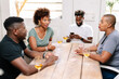 © PICHA - Friends playing cards while enjoying wine at home