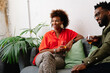 © PICHA - couple sitting on a couch having drinks