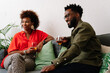 © PICHA - couple sitting on a couch having drinks