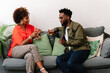 © PICHA - couple sitting on a couch having drinks